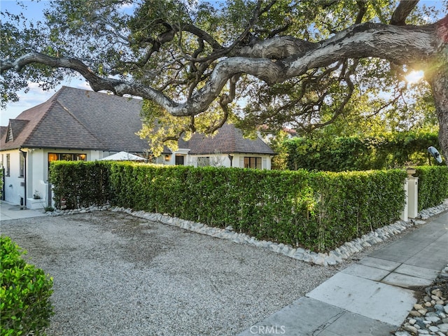 view of property exterior featuring fence private yard, roof with shingles, and stucco siding