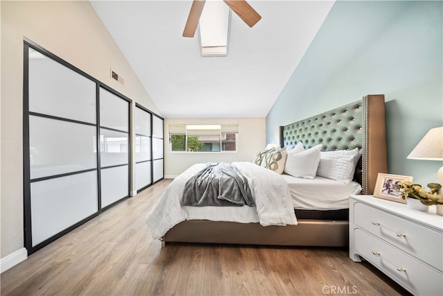 bedroom with vaulted ceiling, visible vents, a ceiling fan, and wood finished floors