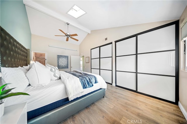 bedroom with baseboards, ceiling fan, beamed ceiling, wood finished floors, and high vaulted ceiling