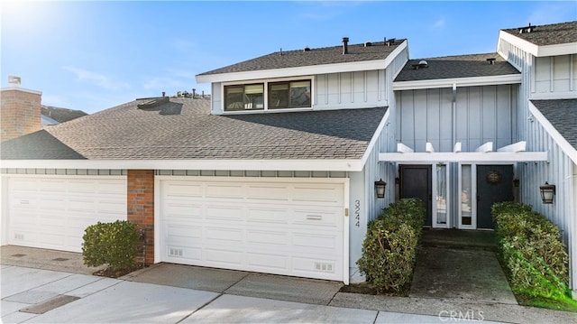 view of front facade featuring a garage, board and batten siding, concrete driveway, and a shingled roof