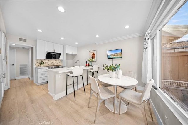 dining area with visible vents, baseboards, recessed lighting, light wood-style floors, and crown molding