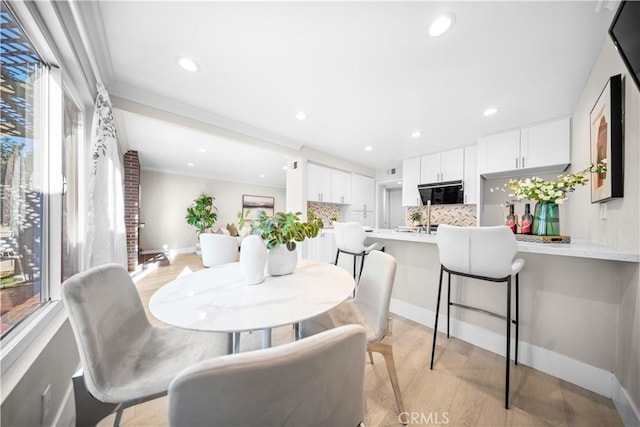 dining room with a wealth of natural light, recessed lighting, crown molding, and baseboards