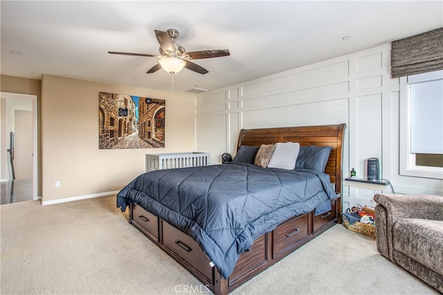 bedroom featuring light colored carpet, baseboards, and a ceiling fan