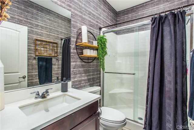 bathroom featuring wallpapered walls, vanity, toilet, and a stall shower