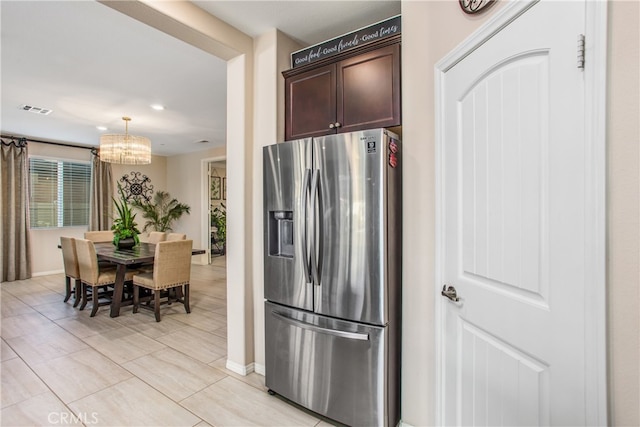 kitchen with dark brown cabinets, baseboards, visible vents, an inviting chandelier, and stainless steel refrigerator with ice dispenser