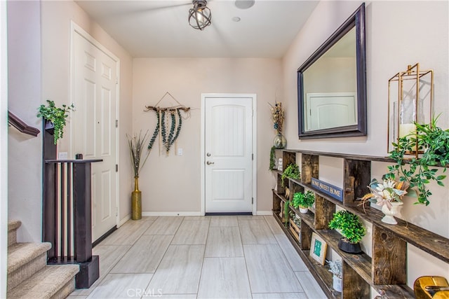 foyer with baseboards and stairs