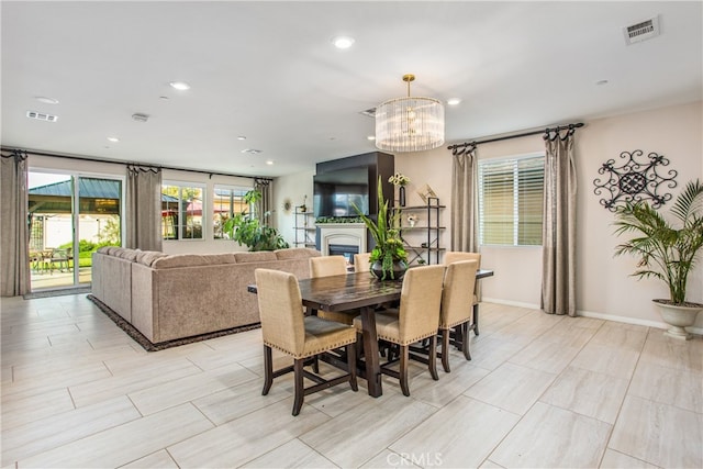 1007 Violet Ct, Calimesa, CA 92320 - dining space with a chandelier, recessed lighting, a glass covered fireplace, and baseboards