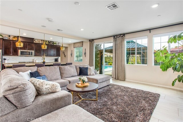 living area featuring visible vents and recessed lighting