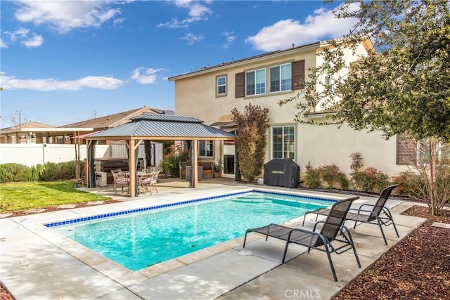back of property featuring a gazebo, a patio area, fence, a fenced in pool, and stucco siding