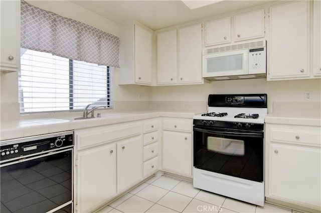 kitchen with range with gas stovetop, black dishwasher, tile countertops, light tile patterned flooring, and white microwave