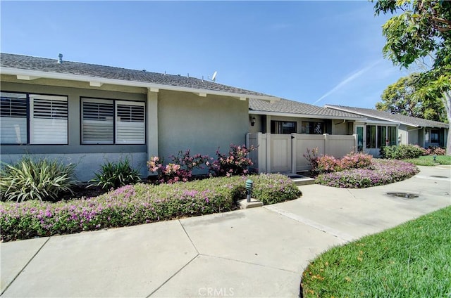 doorway to property featuring stucco siding and fence