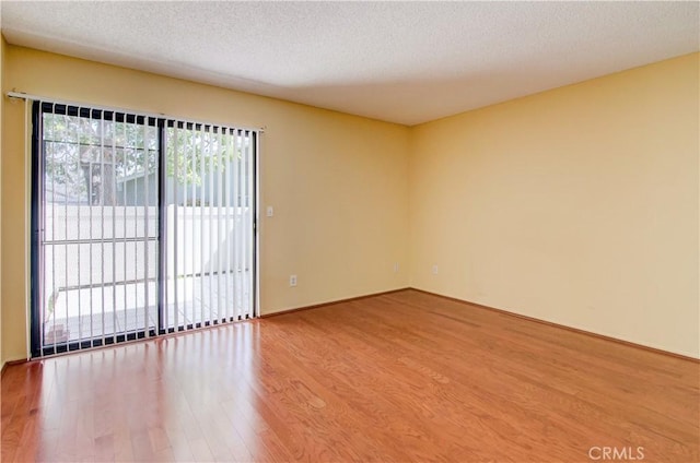 empty room featuring a textured ceiling and wood finished floors