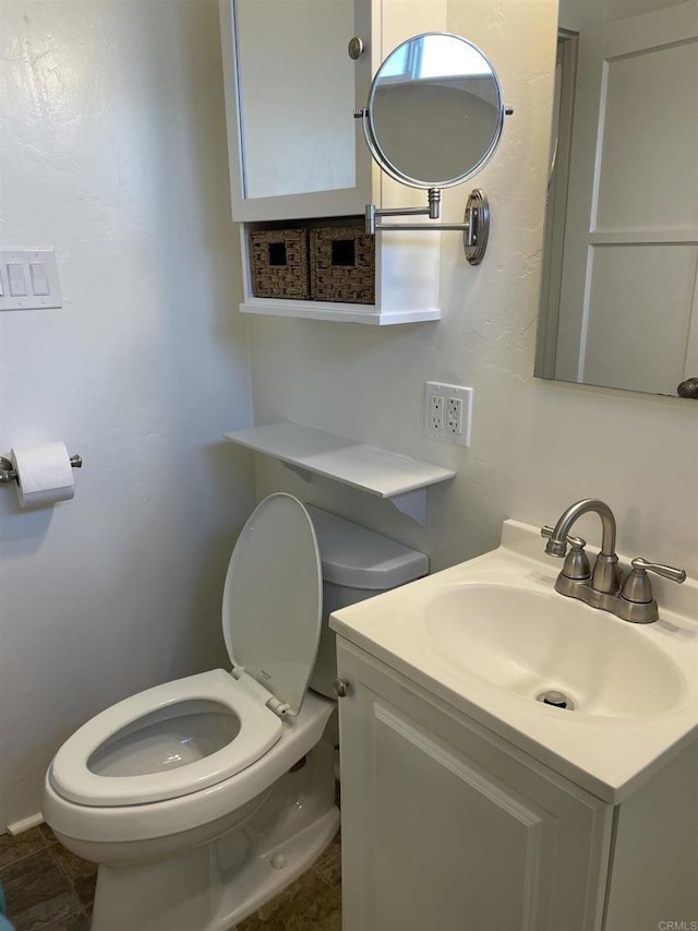 half bathroom featuring vanity and toilet