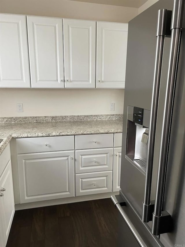 kitchen featuring dark wood finished floors, stainless steel fridge with ice dispenser, and white cabinetry