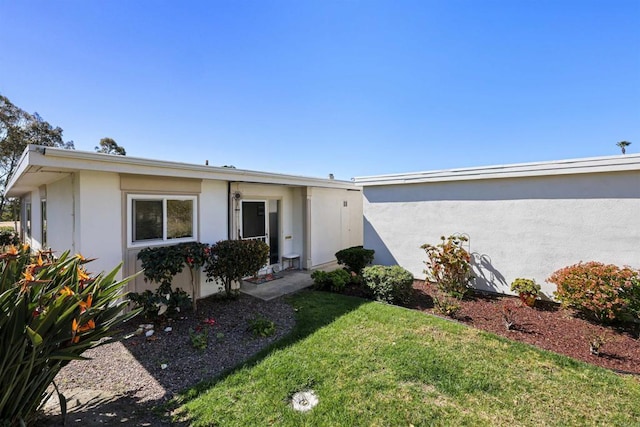 view of front of house featuring stucco siding and a front yard