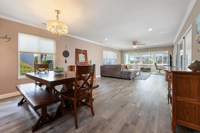 dining room featuring visible vents, crown molding, baseboards, ceiling fan with notable chandelier, and wood finished floors