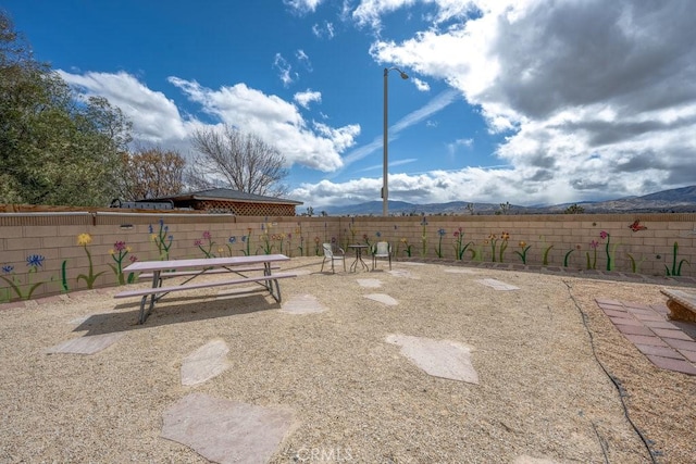 view of yard with a mountain view and a fenced backyard