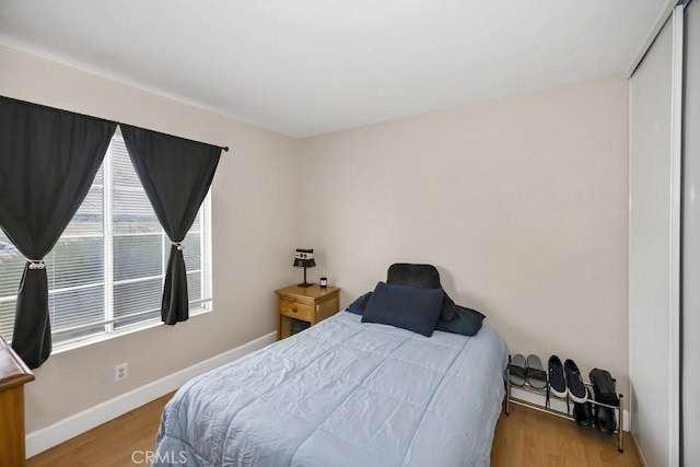 bedroom featuring wood finished floors and baseboards