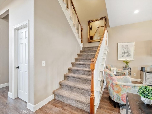 staircase with recessed lighting, baseboards, and wood finished floors