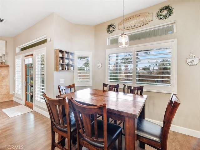 dining area with visible vents, baseboards, and wood finished floors