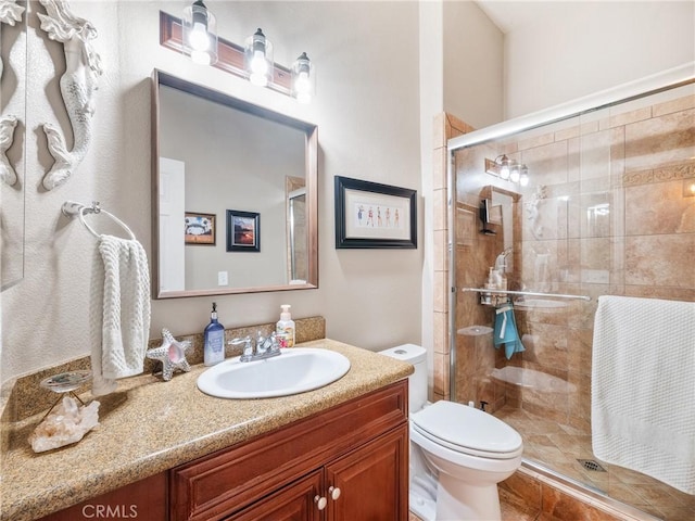 full bathroom with vanity, toilet, and a shower stall