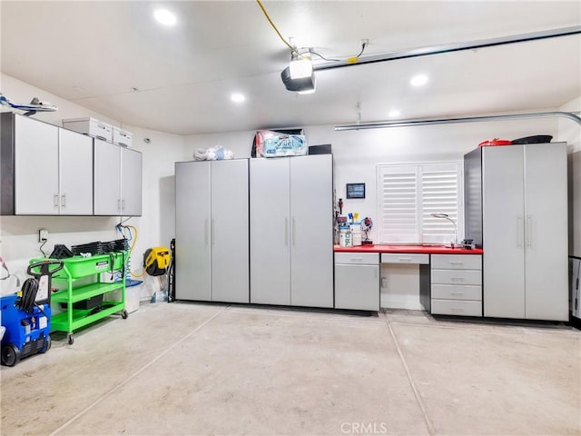 garage with recessed lighting and a garage door opener