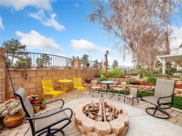 view of patio with a fire pit and fence