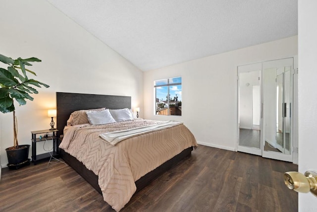 bedroom with lofted ceiling, dark wood-style floors, and baseboards