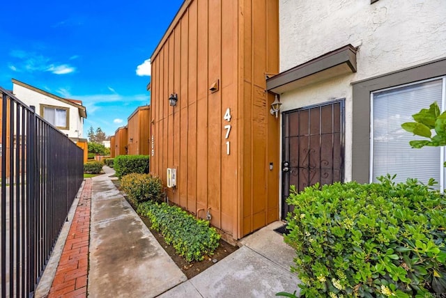 view of home's exterior with stucco siding and fence