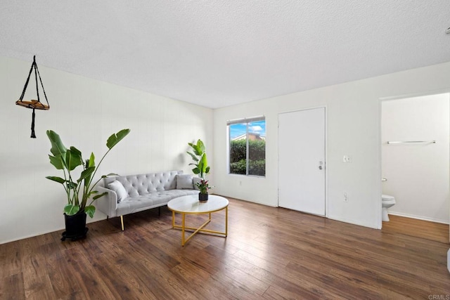 living room with a textured ceiling and wood finished floors