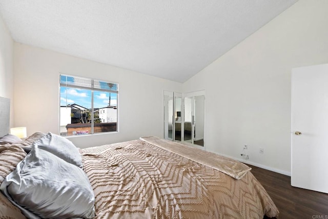 bedroom featuring baseboards, lofted ceiling, and dark wood-style flooring