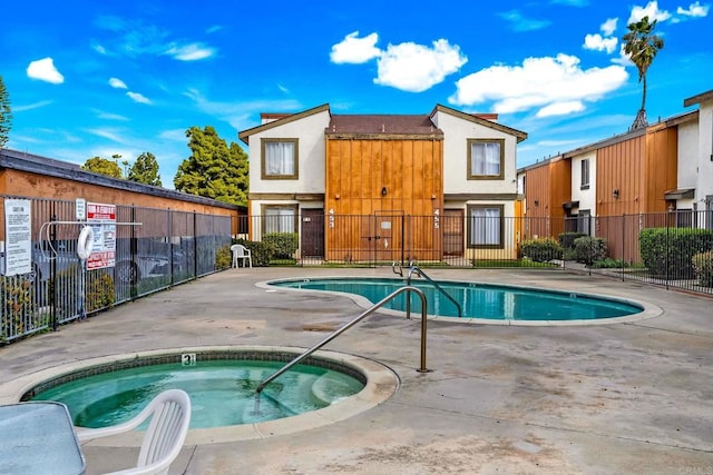 pool featuring a patio, a community hot tub, and fence