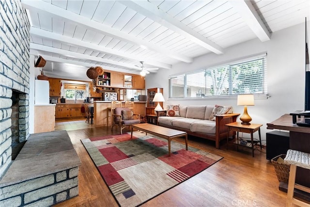 living room with a large fireplace, a healthy amount of sunlight, light wood finished floors, and ceiling fan