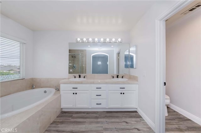 full bathroom featuring visible vents, a shower stall, a garden tub, and a sink