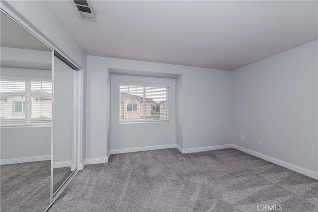 unfurnished bedroom featuring visible vents, baseboards, a closet, and carpet flooring