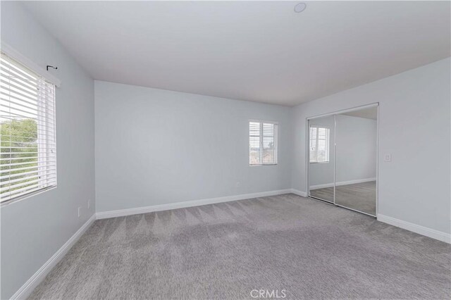 unfurnished bedroom with a closet, baseboards, and carpet