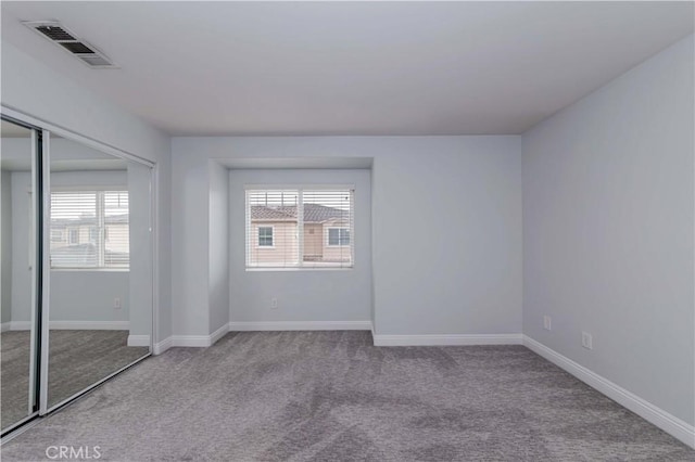 unfurnished bedroom featuring a closet, visible vents, baseboards, and carpet floors