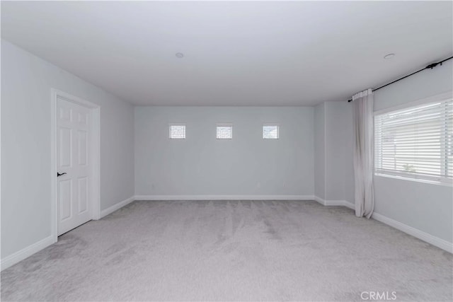 carpeted spare room featuring baseboards