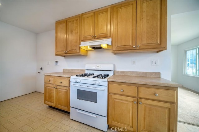 kitchen with under cabinet range hood, gas range gas stove, and light countertops