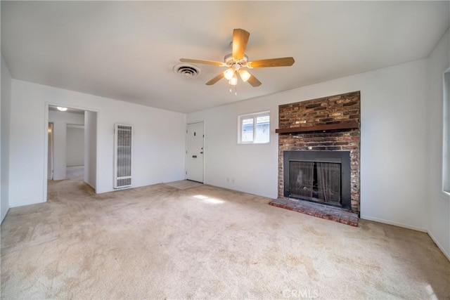 unfurnished living room with light colored carpet, a fireplace, visible vents, and ceiling fan