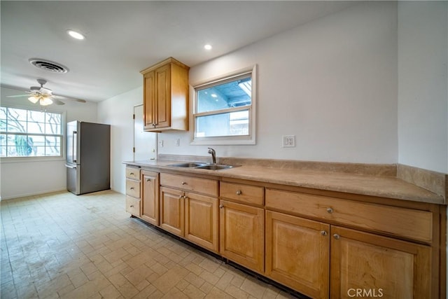 kitchen featuring visible vents, plenty of natural light, freestanding refrigerator, and a sink