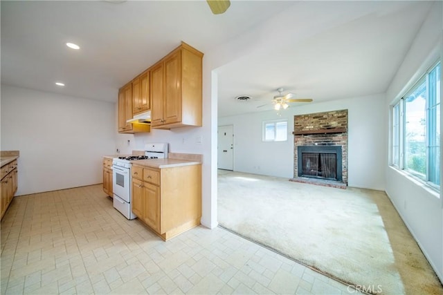 kitchen featuring white range with gas cooktop, light carpet, a ceiling fan, recessed lighting, and light countertops