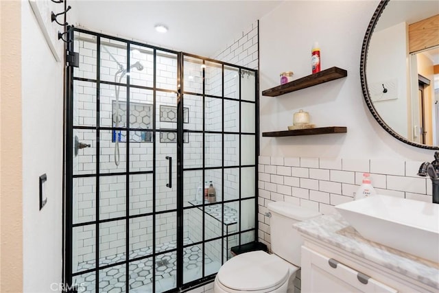 full bathroom with vanity, a shower stall, toilet, and tile walls