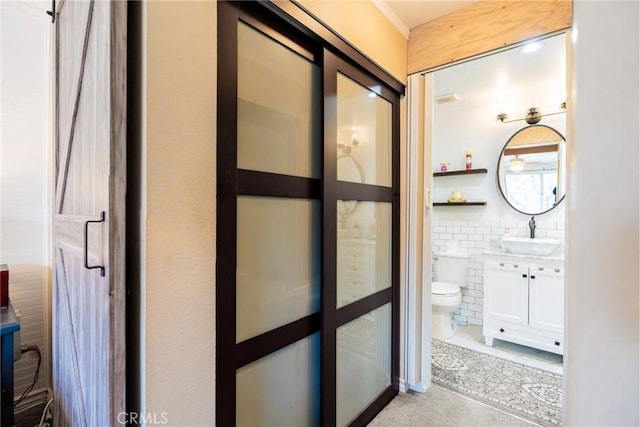 hallway with tile walls and a sink