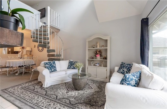 living room featuring stairway and lofted ceiling