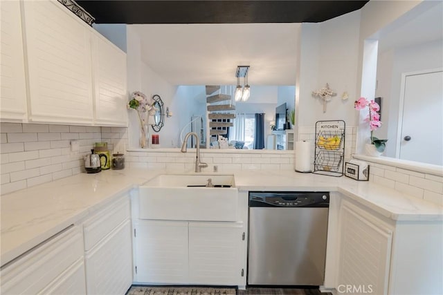 kitchen with decorative backsplash, stainless steel dishwasher, and white cabinets