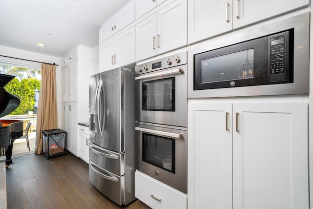 kitchen featuring appliances with stainless steel finishes, white cabinetry, and dark wood-type flooring