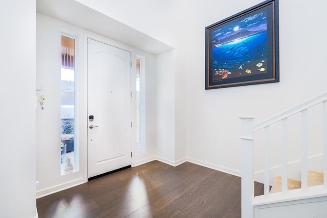 foyer with dark wood finished floors and baseboards