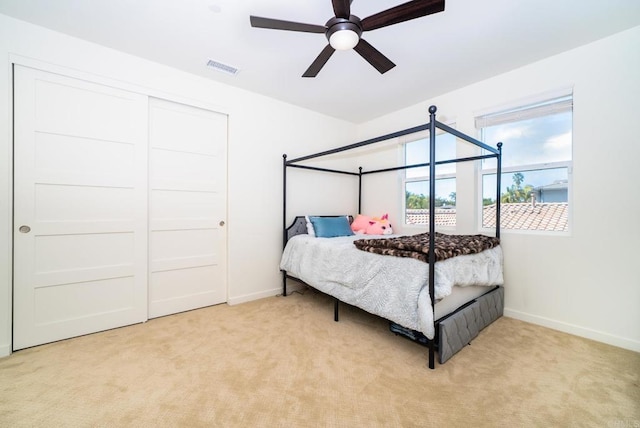 carpeted bedroom with visible vents, baseboards, and a ceiling fan