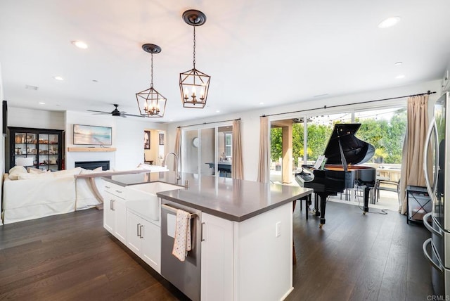 kitchen featuring dark wood finished floors, open floor plan, appliances with stainless steel finishes, and a sink